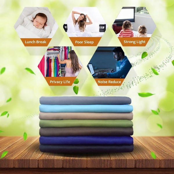Stack of folded multi-colored blackout curtain fabrics in various shades on a wooden surface.