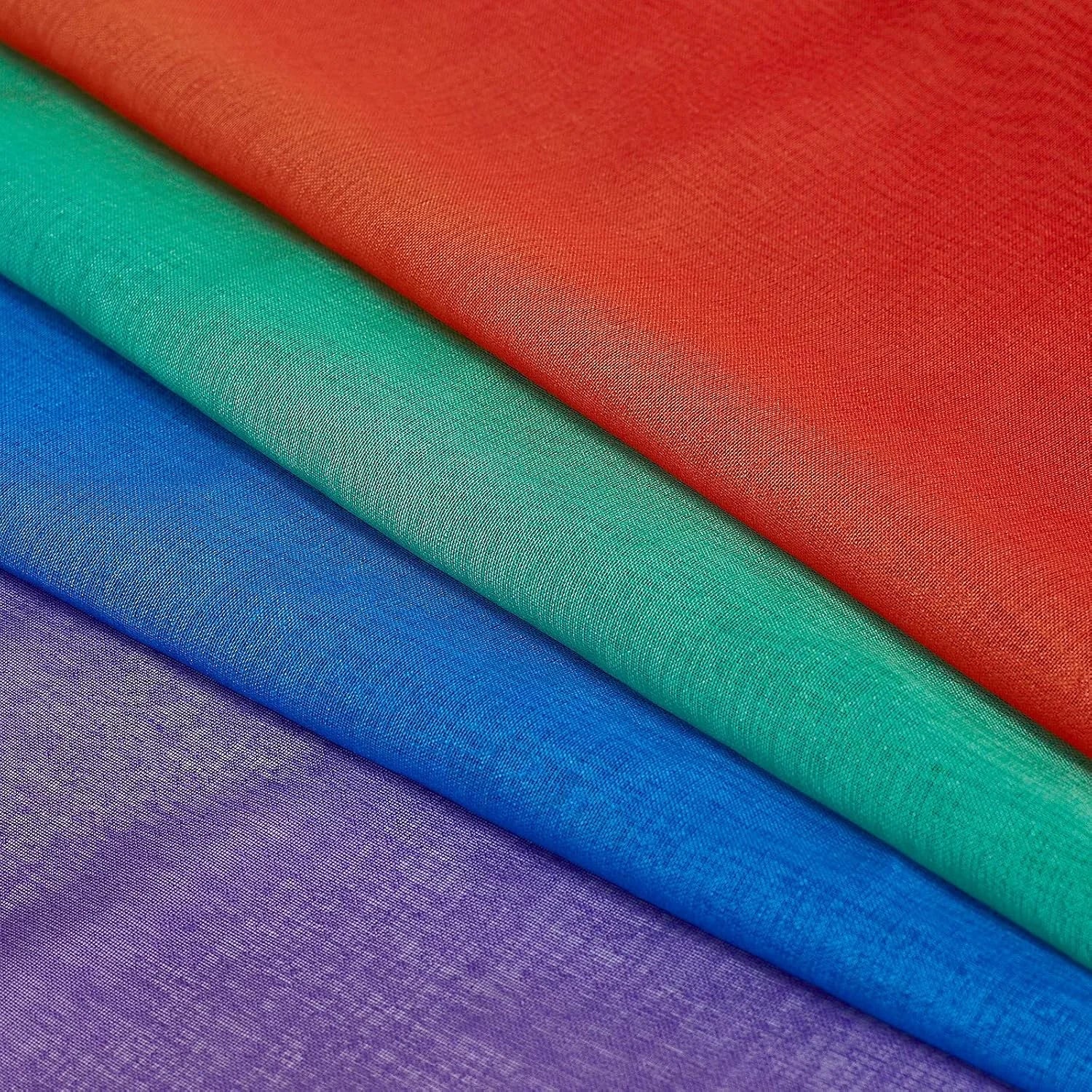 Layered sheer fabric swatches in red, teal, blue, and purple close-up