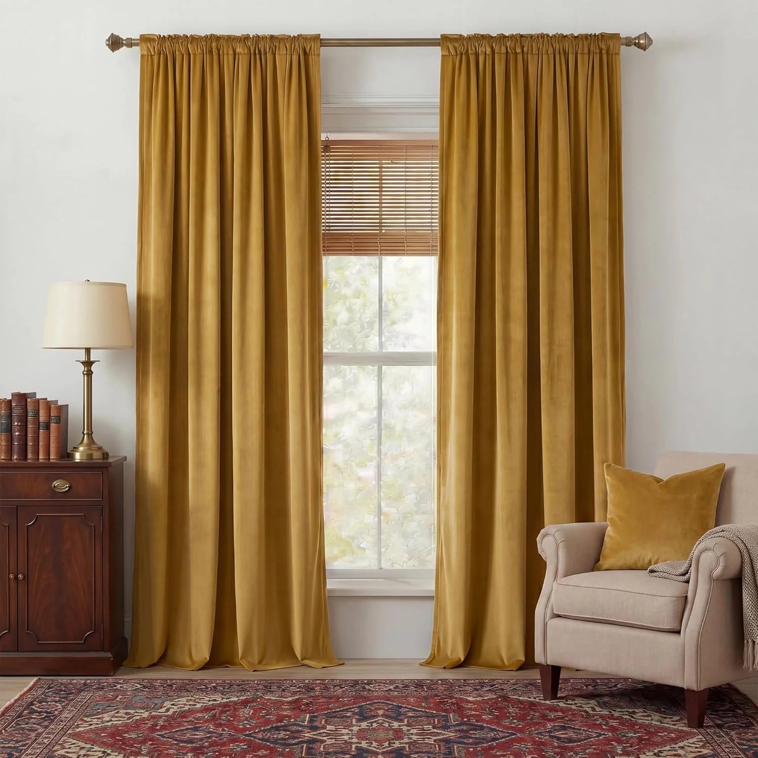 Mustard velvet rod pocket curtains hanging in a cozy traditional living room window