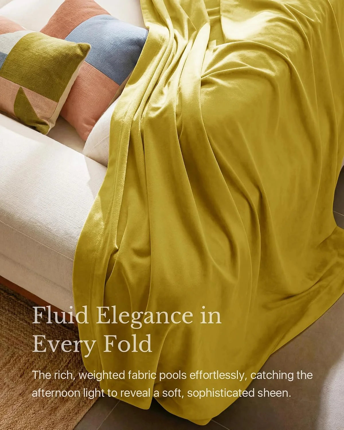 Mustard velvet throw blanket draped over a cream sofa with color-block pillows