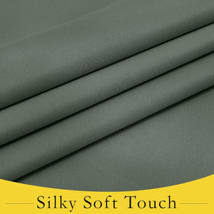 Close-up of folded muted green fabric showing its smooth, soft, and slightly textured surface.