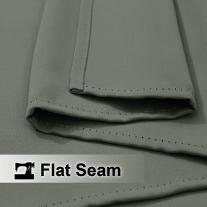 Close-up of muted grey fabric with a folded edge showing a neatly executed flat seam and fine, even stitching.