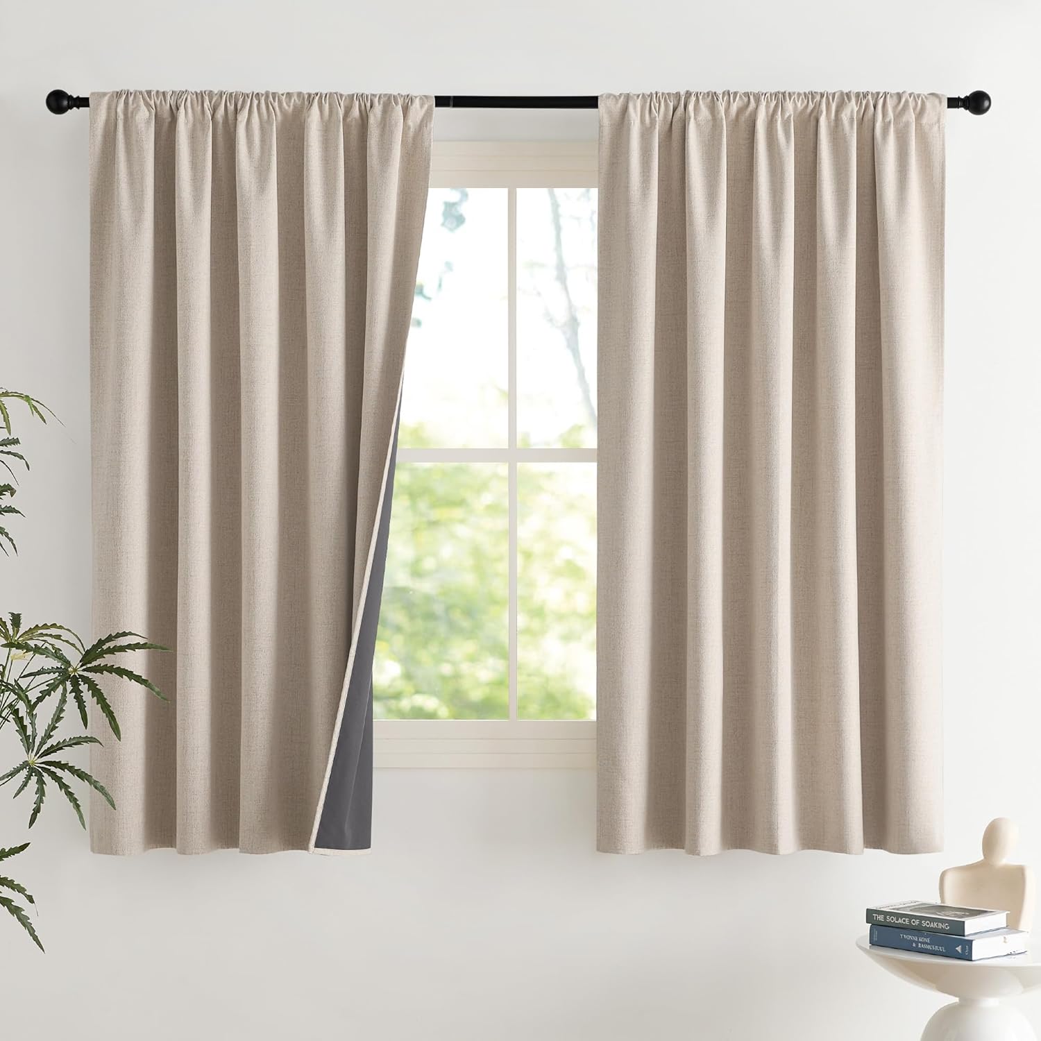 Beige linen-textured curtains with gathered rod pocket top, showing dark gray blackout lining.