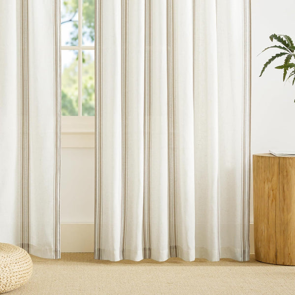 Natural cream linen-look curtain panels with subtle vertical taupe stripes cover a sunlit window.