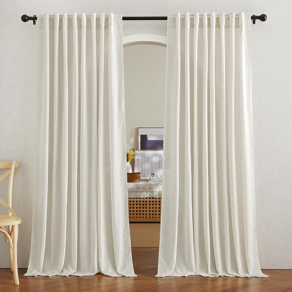 Cream light-filtering linen curtains with pleated top, hanging from a black rod over an arched entryway.