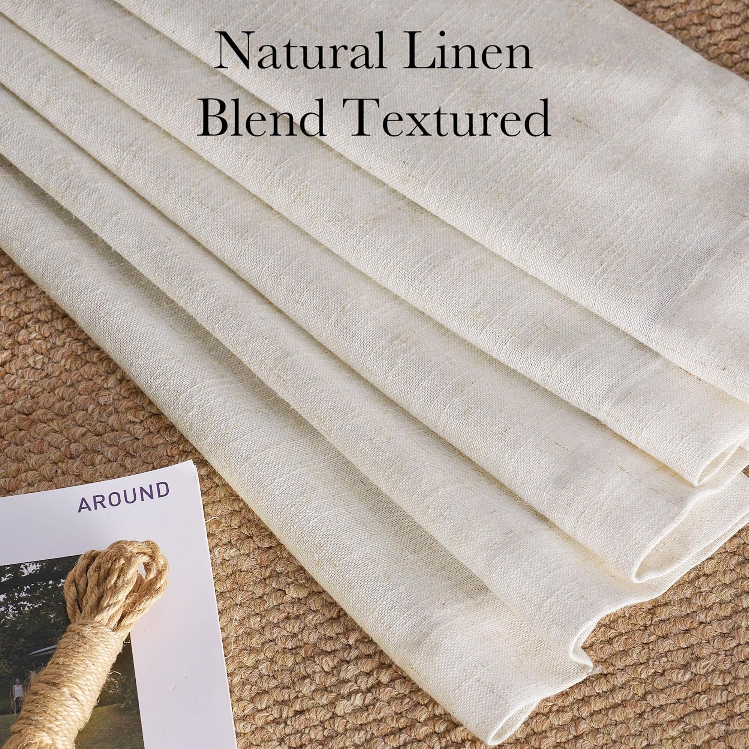 Close-up of folded natural linen blend textured drapery fabric in light cream on a woven jute rug.