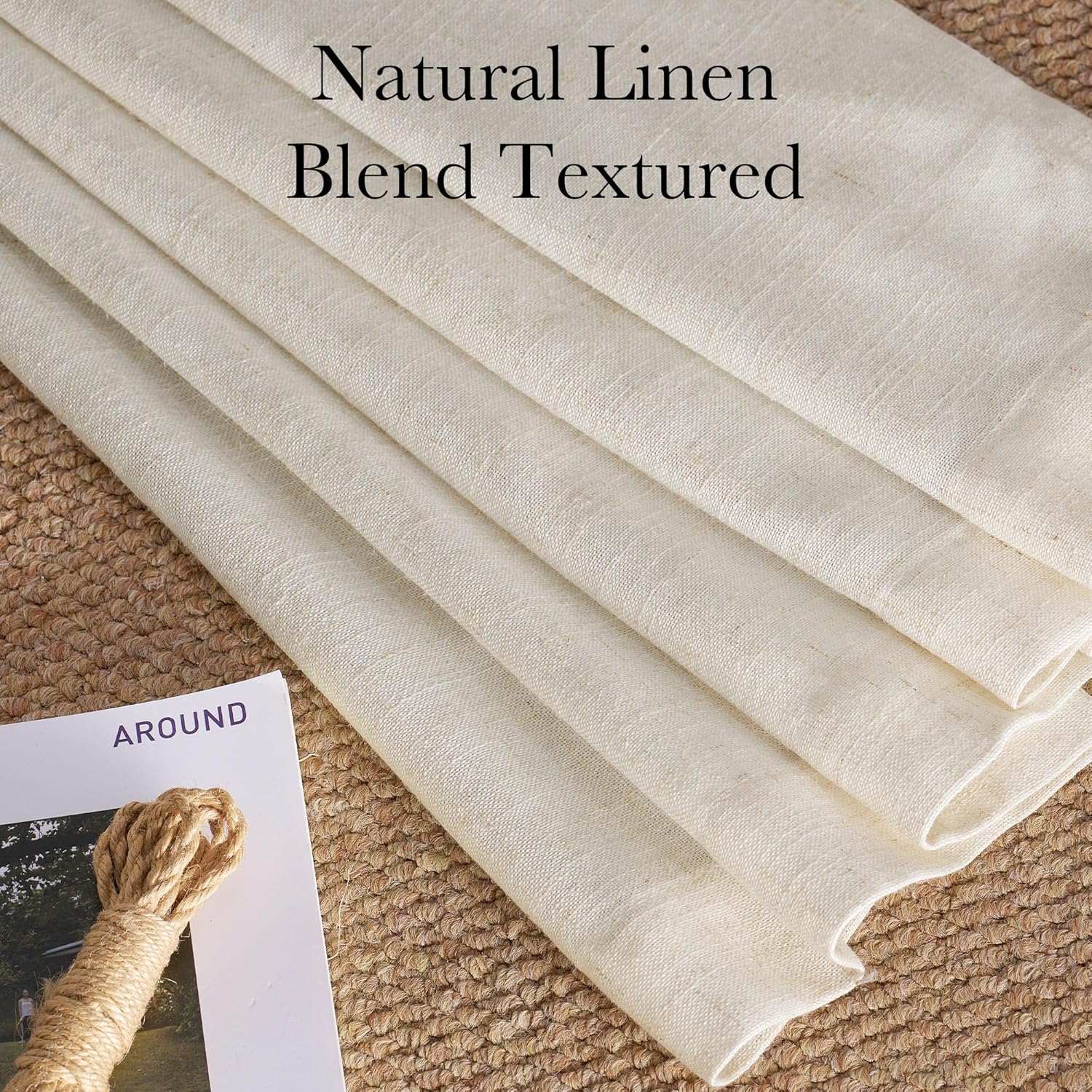Folded natural linen blend fabric in light cream, showcasing its visible textured weave on a rustic jute mat.