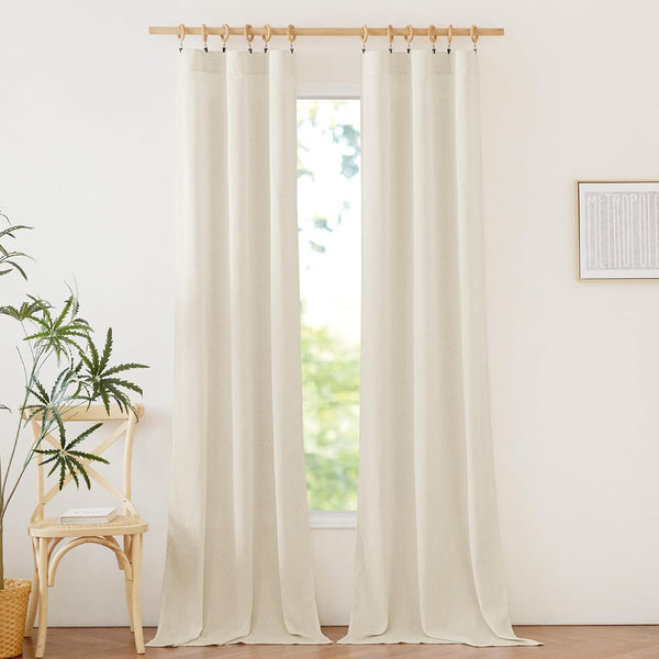Natural linen light filtering curtains hung with wooden clip rings on a rod, showing off-white textured fabric.