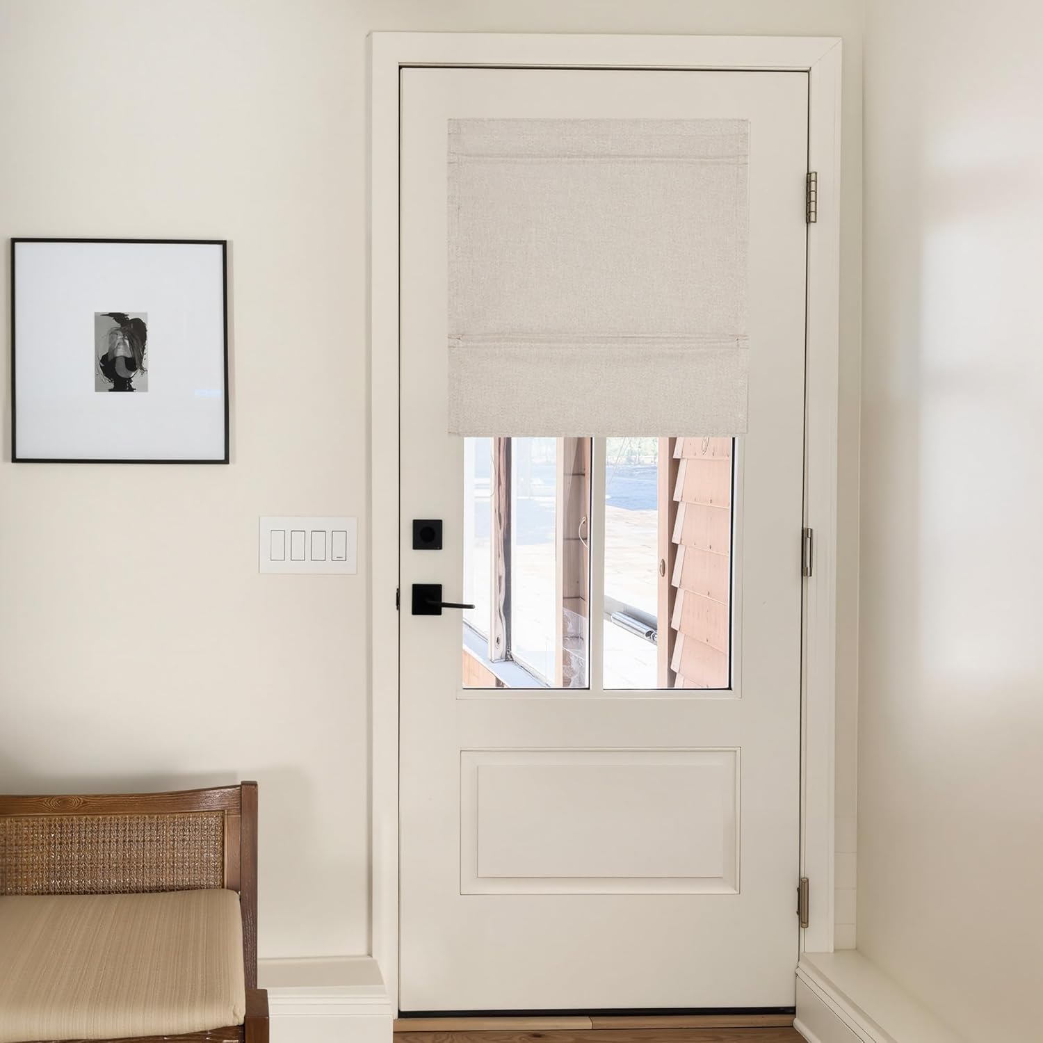 Light beige linen flat Roman shade mounted on a white door window, offering privacy and filtered light.
