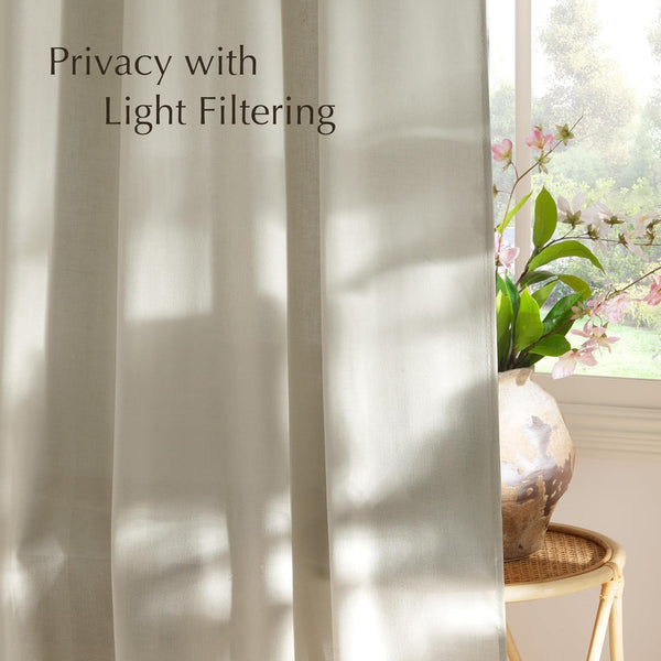 Natural linen light filtering curtain in light beige, casting soft sunlight shadows. Provides privacy.