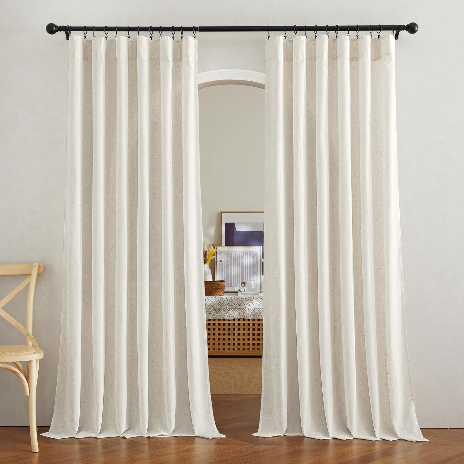 Natural linen pleated curtains hung from a black rod over an arched doorway, offering light filtering.