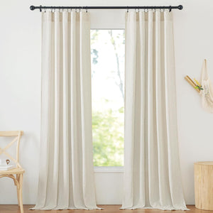 Light beige natural linen curtains hung with black rings on a rod, framing a bright room window.