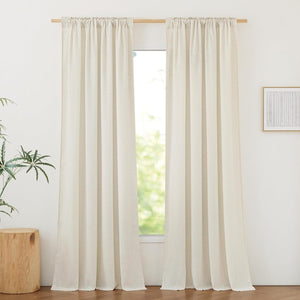Two light beige linen rod pocket curtain panels hanging on a wood rod, filtering sunlight.