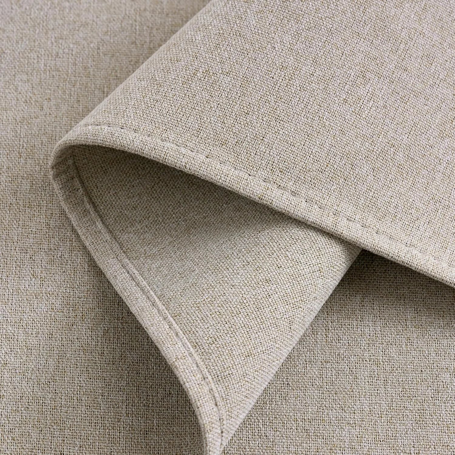 Close-up of natural beige woven fabric texture with stitched fold