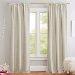 Natural oatmeal textured rod pocket curtains hanging on a wooden rod in a bright room.
