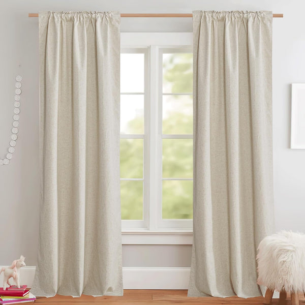 Natural oatmeal textured rod pocket curtains hanging on a wooden rod in a bright room.