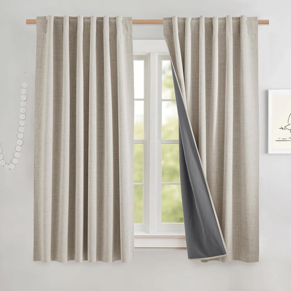Natural beige textured blackout curtains with dark gray lining, one panel pulled back on a wooden rod.