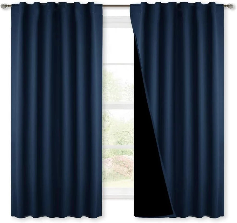 Navy blackout curtains with rod pocket top hanging on a silver curtain rod