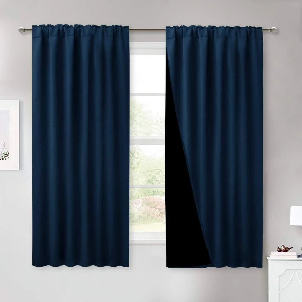 Navy blue blackout curtains with rod pocket top hanging on a silver curtain rod