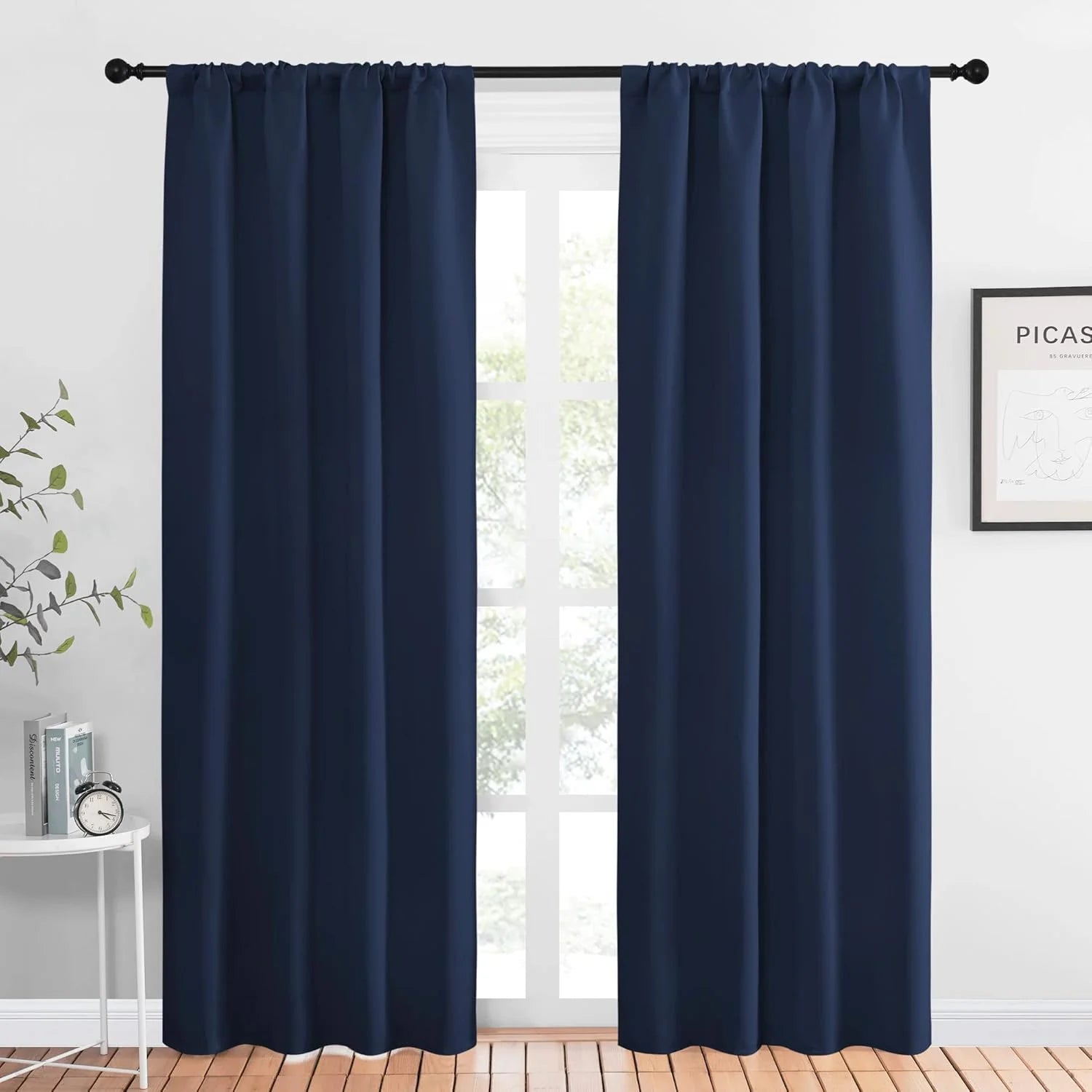 Dark navy blackout curtains on a black rod in a bright modern room