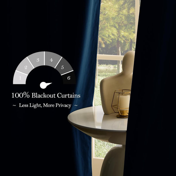 Navy blue 100% blackout curtain blocking light from a window. Modern table with abstract decor and candle.
