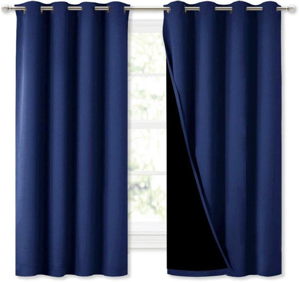 Navy blue blackout curtains with silver grommet tops, one panel open revealing the dark lining.