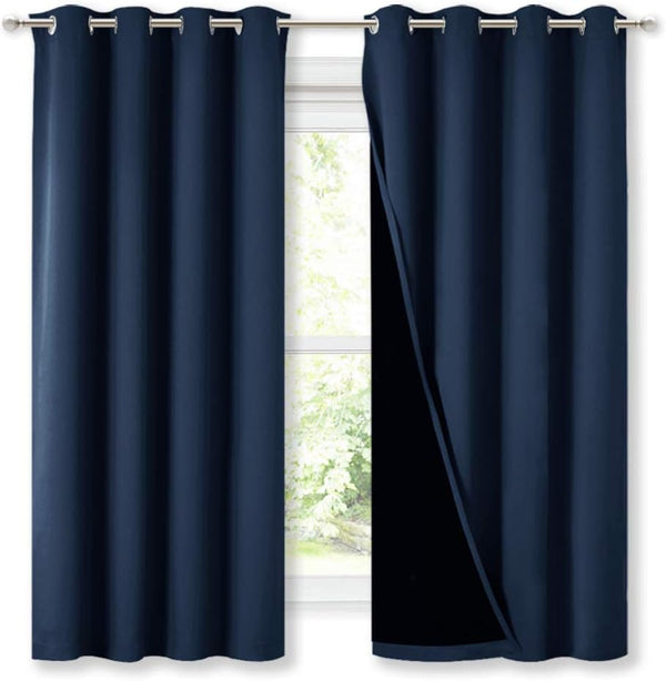 Navy blue blackout curtains with silver grommet tops on a window, revealing dark lining.