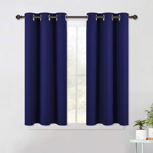 Two navy blue blackout curtain panels with silver grommets hang on a brown rod over a window.