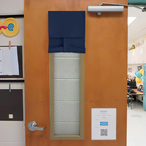 Navy blue fabric blackout shade on a classroom door window with internal security wire mesh.