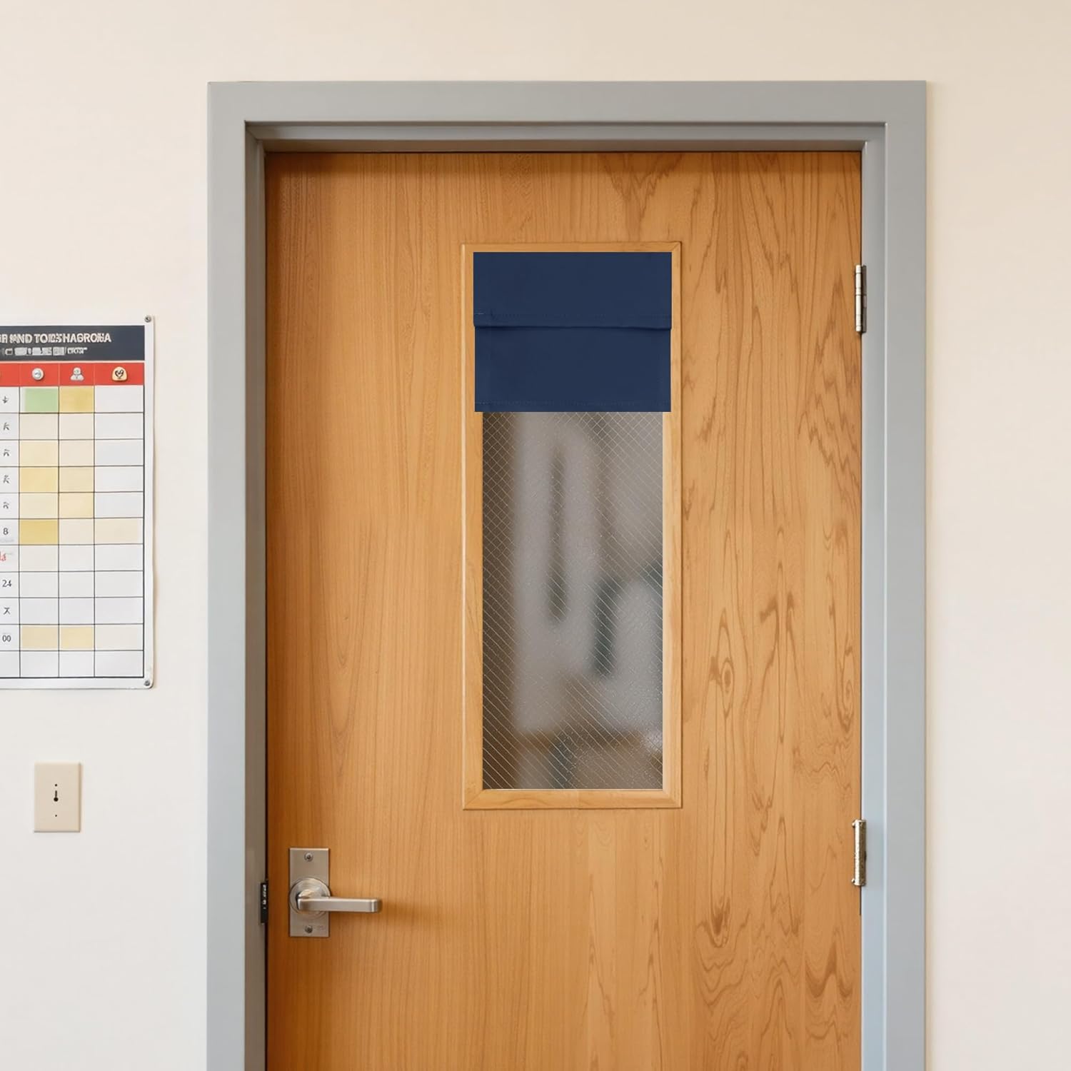 Navy blue fabric privacy shade covering the top portion of a textured glass window on a light brown wooden door.