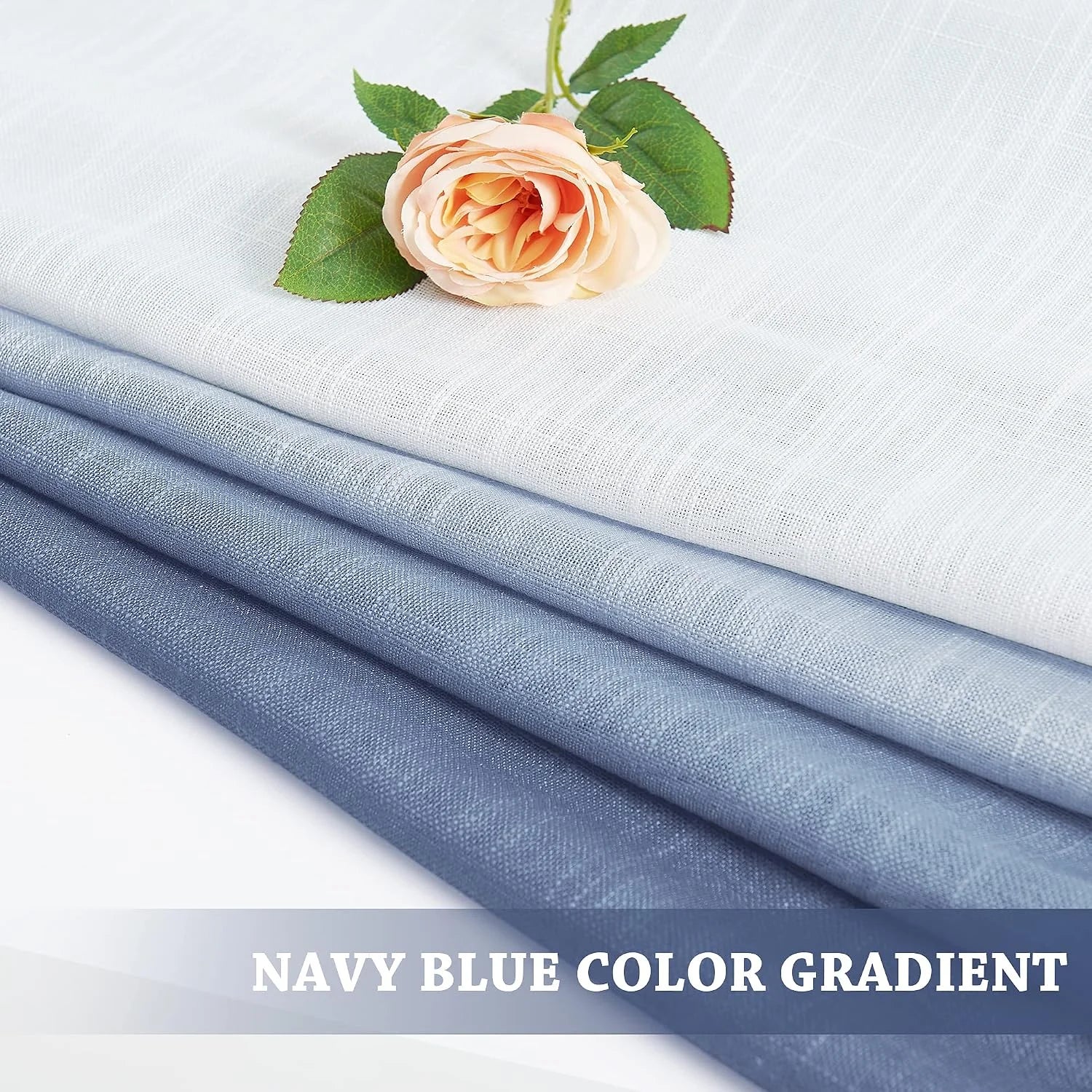 Folded navy blue gradient linen fabric swatches with a peach rose on top