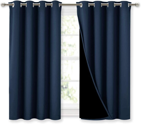 Deep navy blue curtains with silver grommet tops on a rod, one panel revealing its blackout lining.