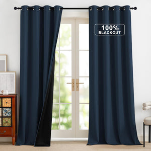 Navy blue blackout curtains with metal grommet top, one pulled back revealing black lining.