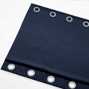 Close-up view of a deep navy blue curtain panel with silver-toned grommet eyelets.
