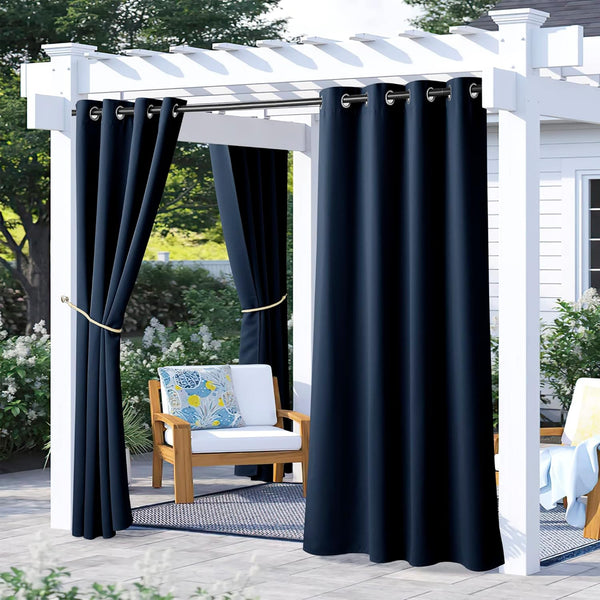 Navy blue outdoor grommet curtains on a white pergola, with one panel tied back. Ideal for patio shade and privacy.