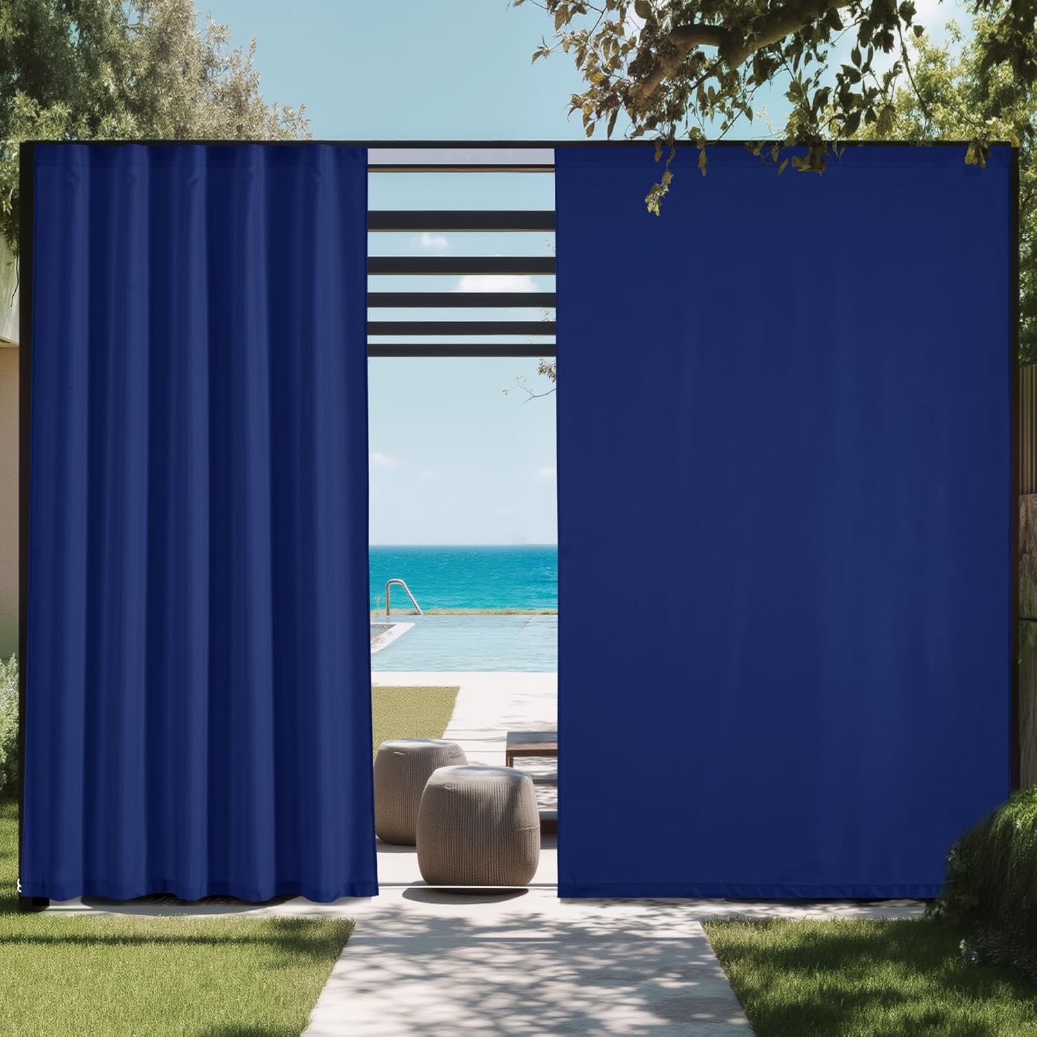 Navy blue outdoor privacy curtains hanging on a modern patio frame next to a swimming pool with an ocean view.