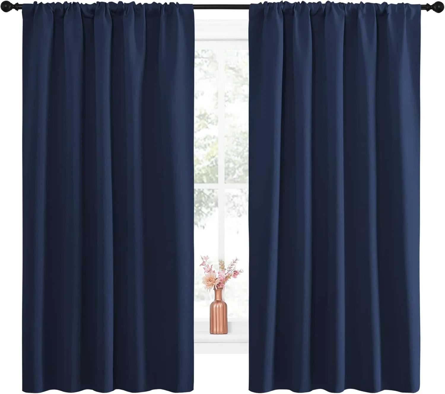 Dark navy blue rod pocket curtains on a black rod, with a vase of pink flowers on the window sill.