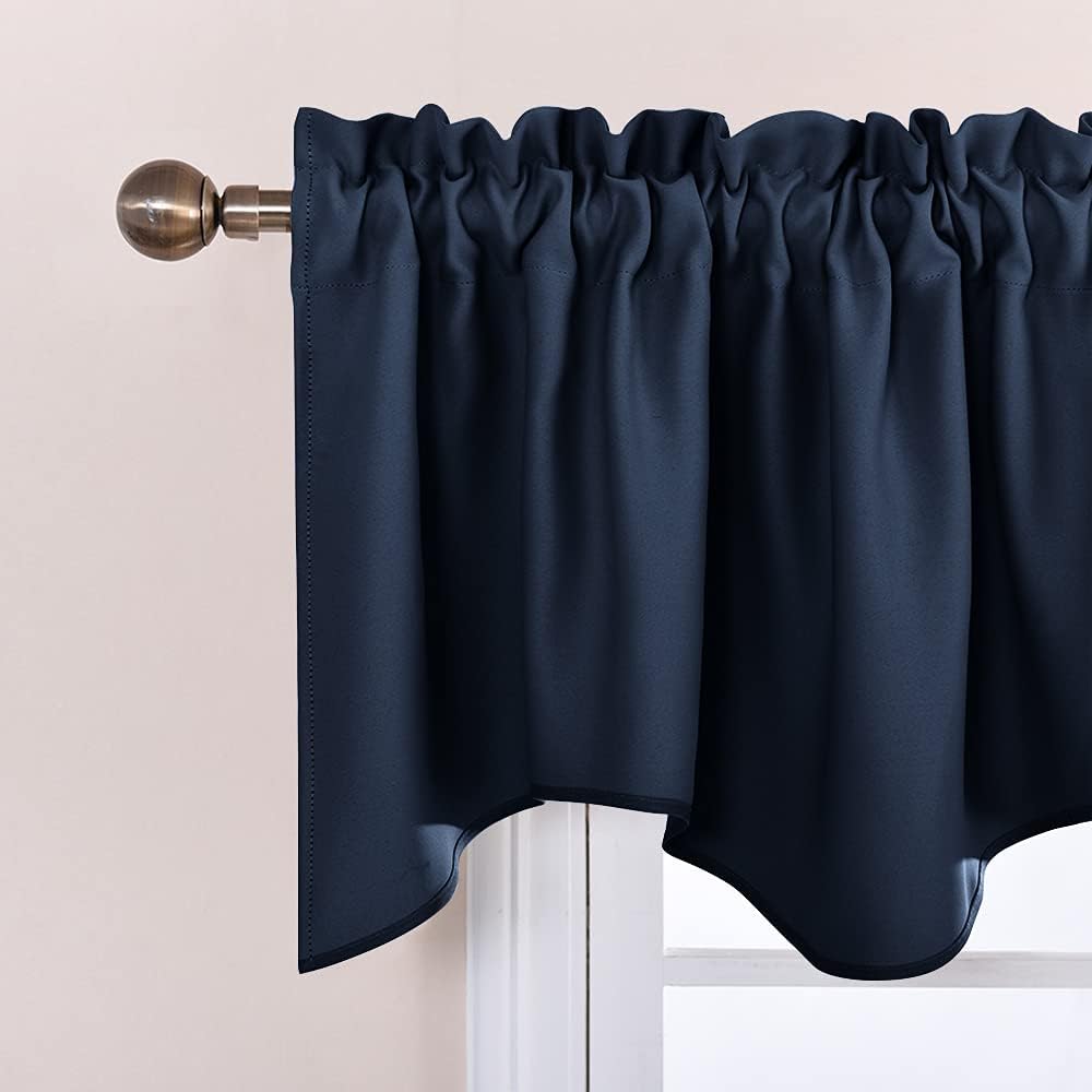 Navy blue rod pocket window valance with gathered top and decorative scalloped bottom, on a brass rod.