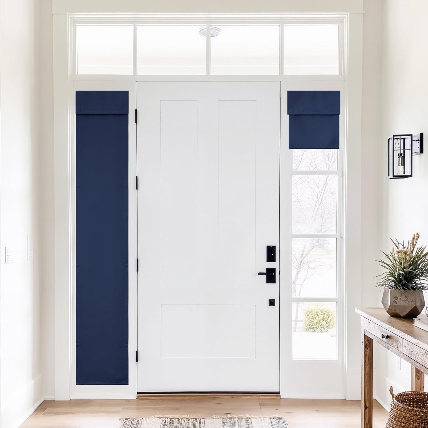 Navy blue fabric privacy shades cover sidelight windows flanking a white front door in a bright entryway.