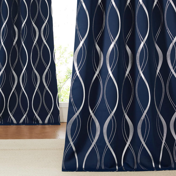 Elegant navy blue curtains with shimmering silver vertical wave patterns hanging by a sunlit window.