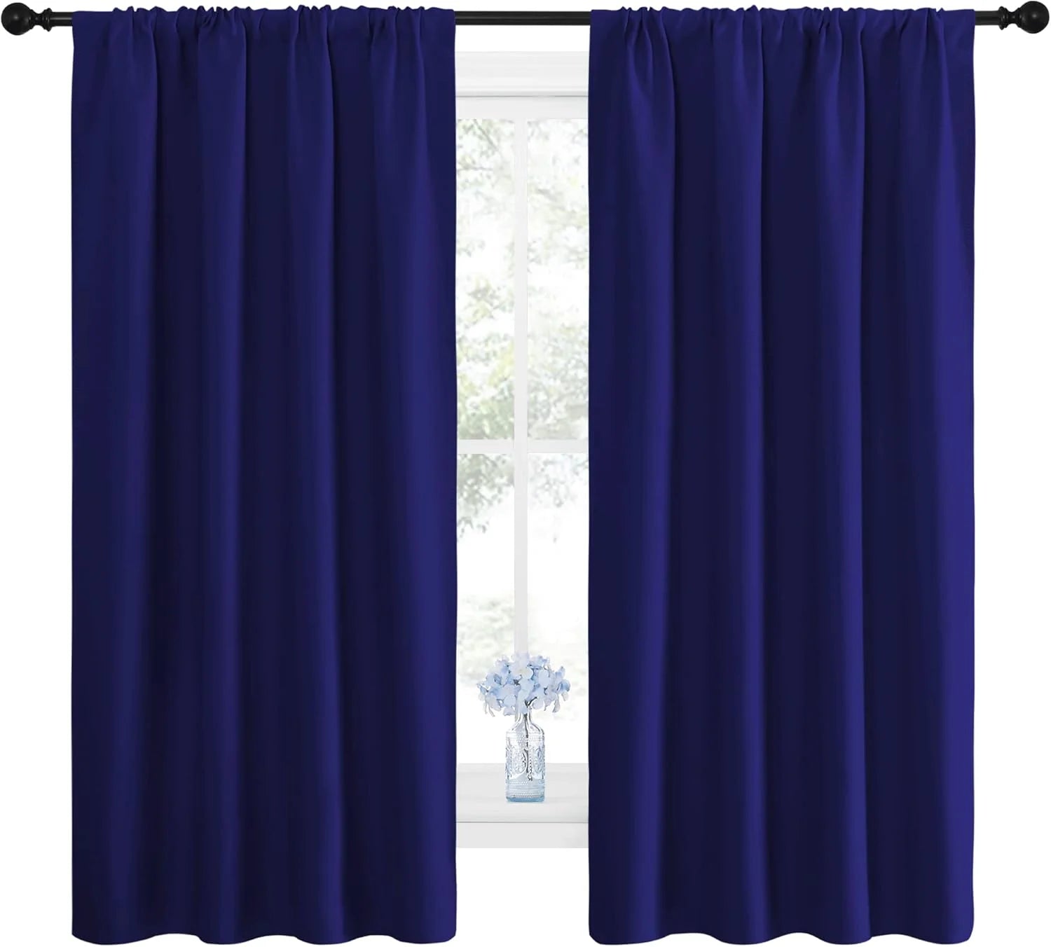 Solid navy blue window curtains with rod pocket heading, framing a bright window.
