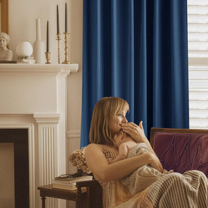 Rich navy blue thermal blackout curtain panel with elegant pleats, enhancing a cozy room.