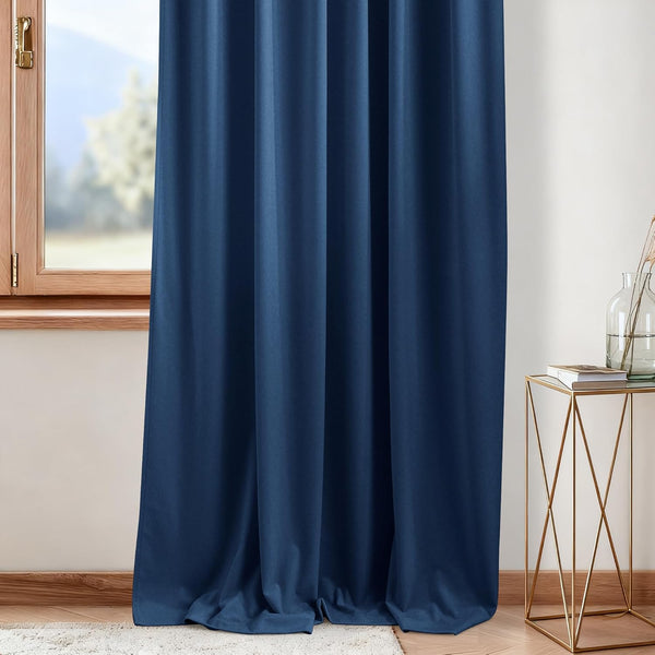 Elegant navy blue velvet blackout curtain panel drapes fully over a wooden window frame.