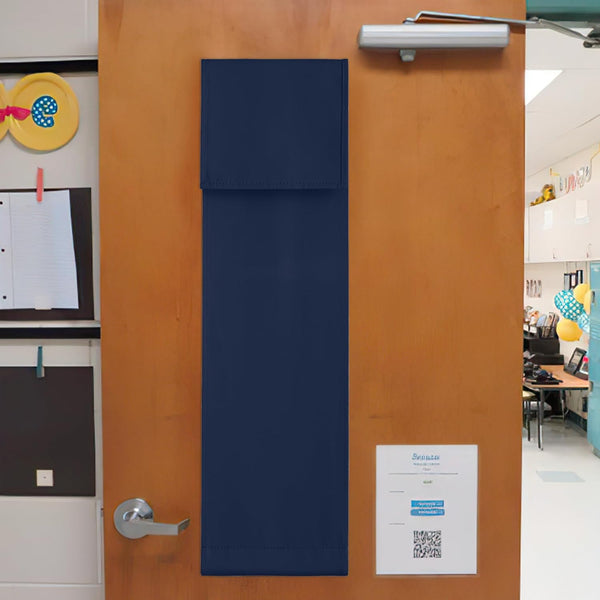 Navy blue fabric door window privacy cover hanging on a light brown classroom door. Features a stitched top flap.