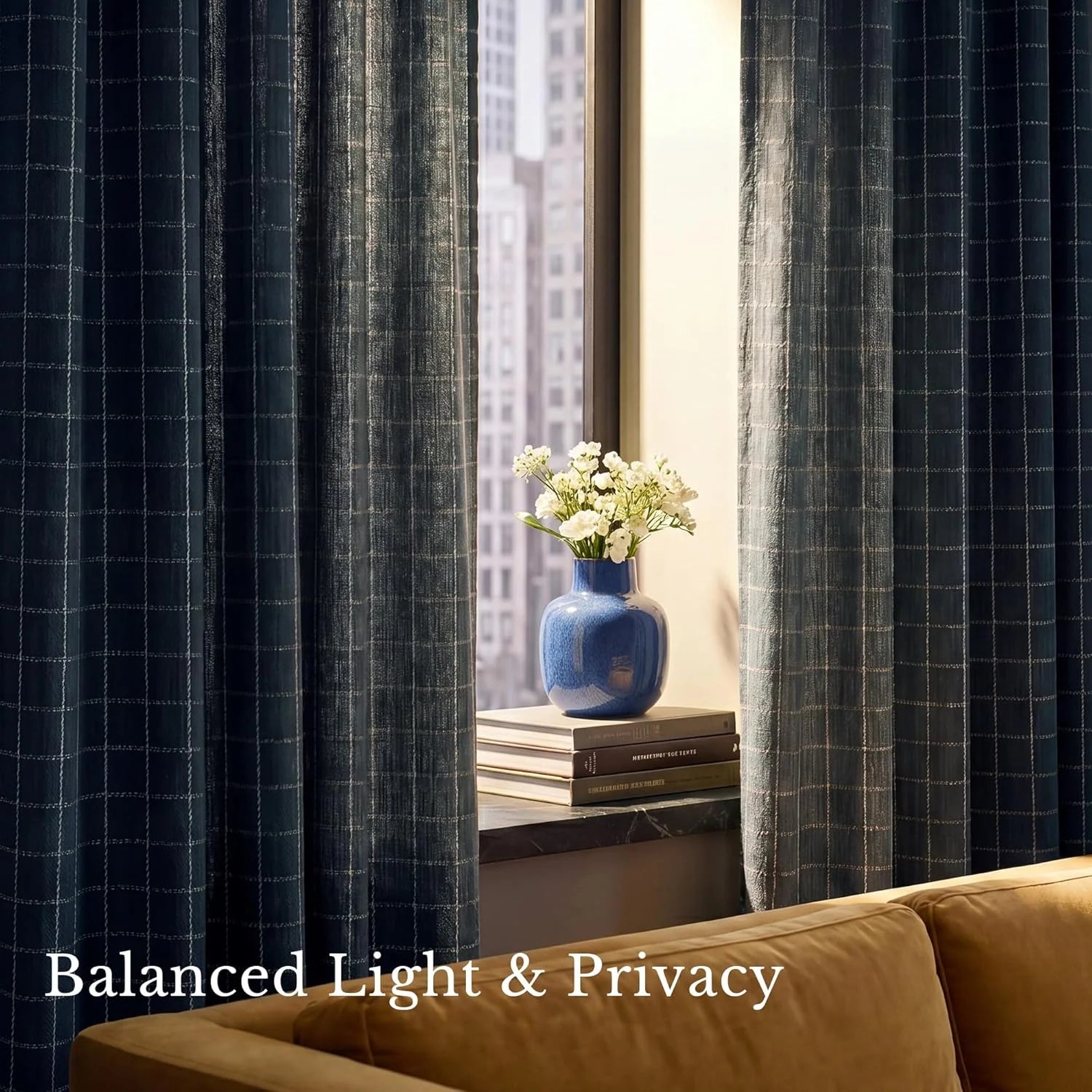 Navy grid patterned sheer window curtains in a modern city apartment setting.