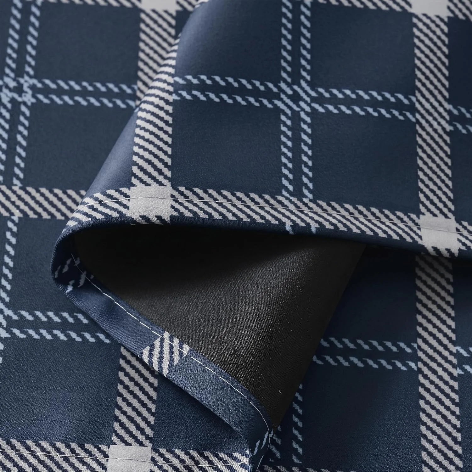 Close-up of navy plaid blackout curtain fabric with white check pattern and black lining