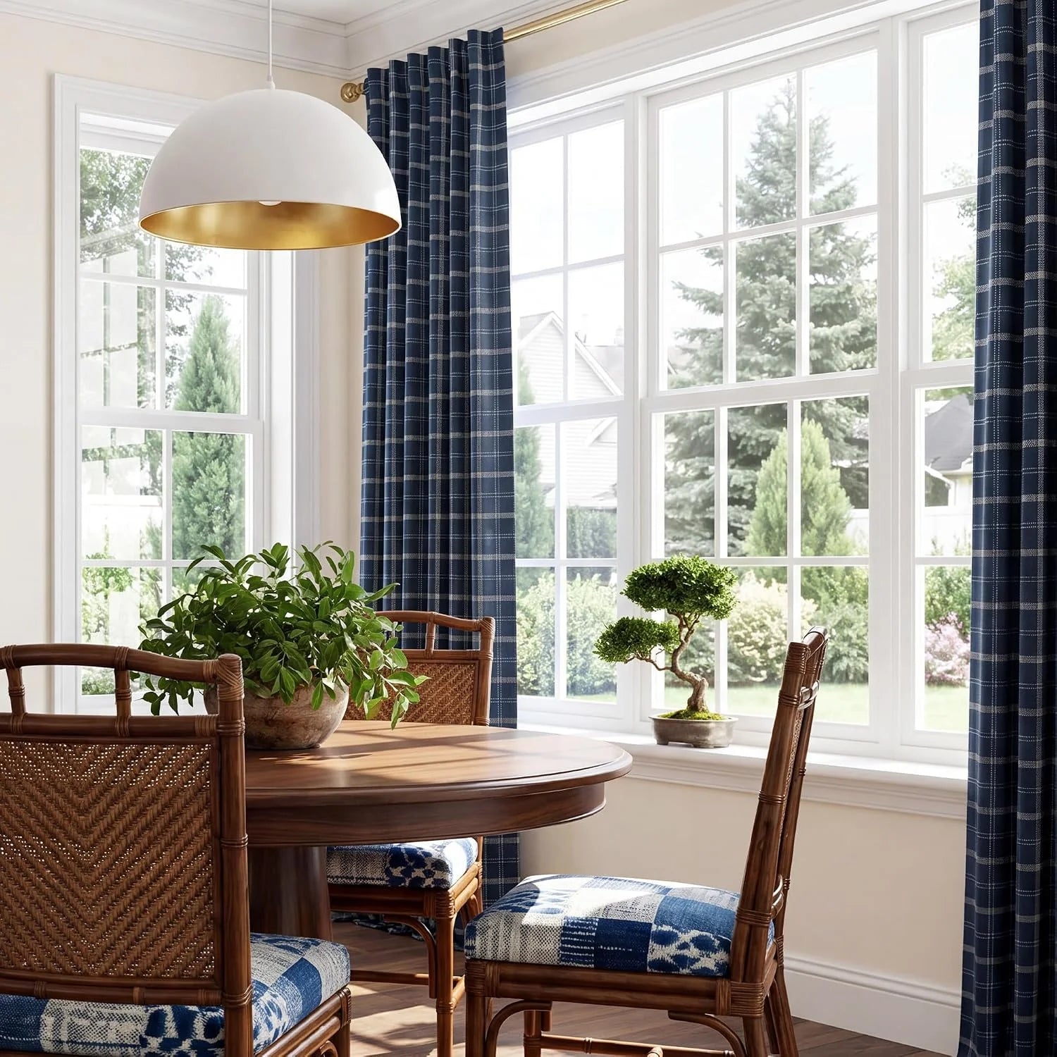Navy plaid curtains framing large windows in a bright dining room with rattan chairs