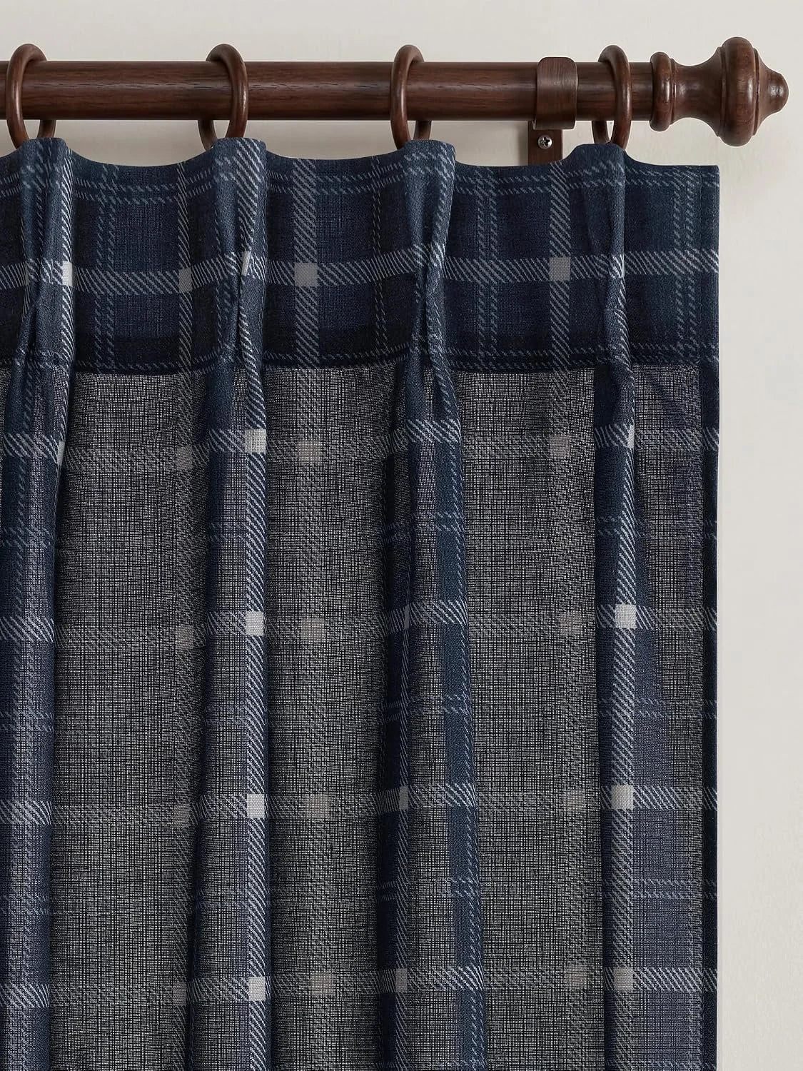 Navy plaid sheer curtain panel hanging from a dark wooden rod with tab top