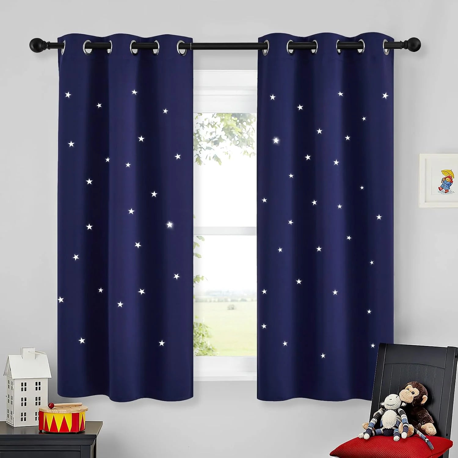 Navy blackout curtains with white star cutouts on grommet top in a kids room