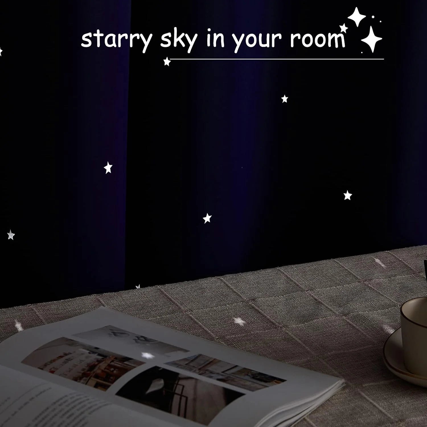 Dark navy blackout curtains with star cutouts casting light onto a table